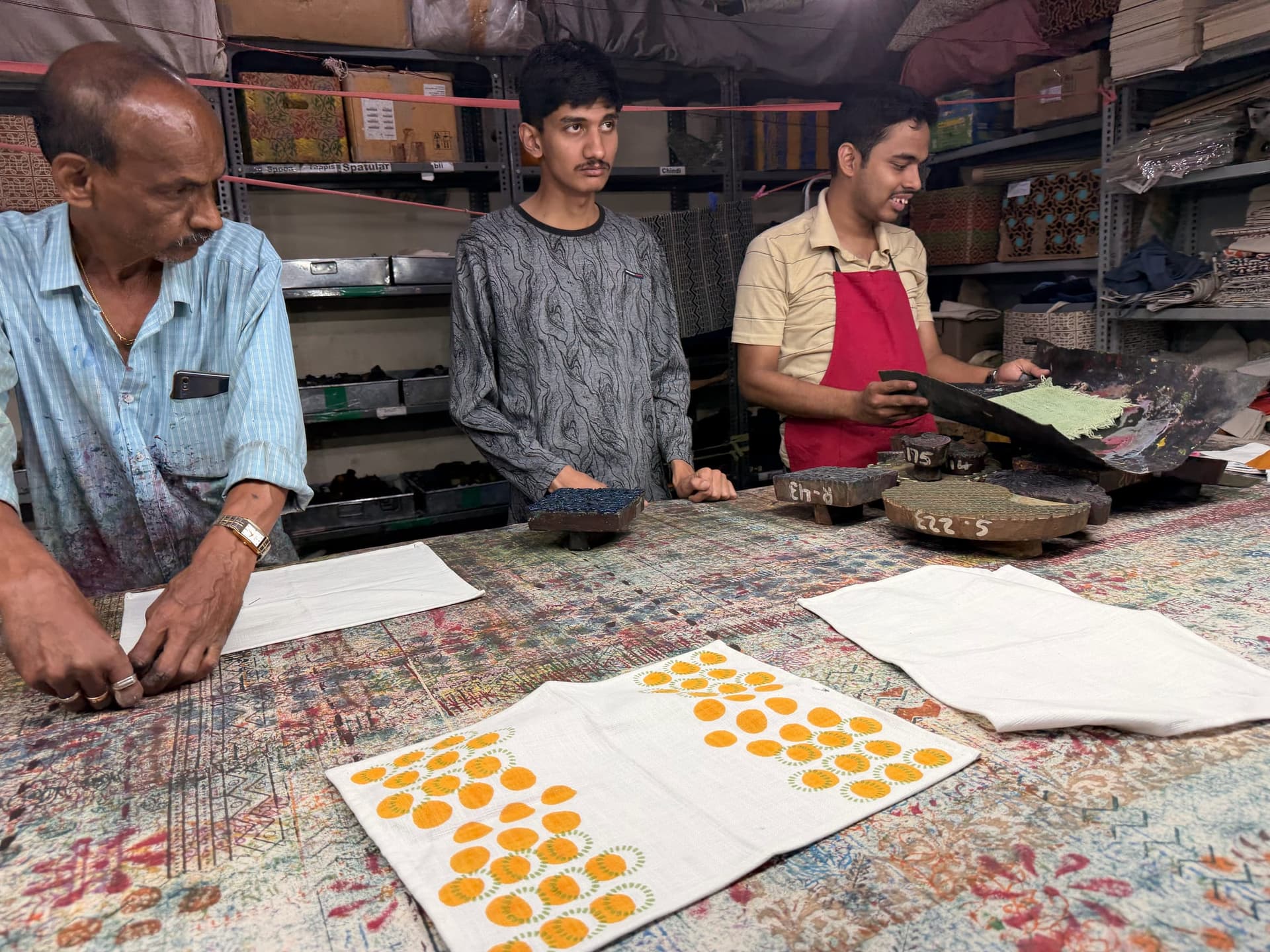 Makers print mustard dot table runners at the long studio table