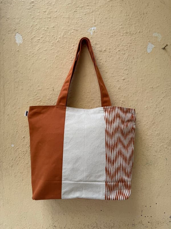 Large colour-block tote in rust and cream canvas with a woven chevron stripe panel